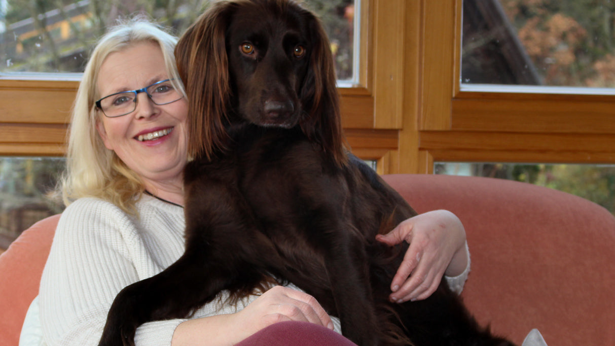 Bild der Fachbuchautorin Kristina Vormwald, auf einem Sofa sitzend und ihren Hund, einen Deutsch Langhaar namens Chilli, neben sich